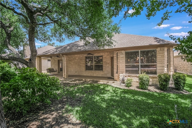 back of property with a lawn and a patio