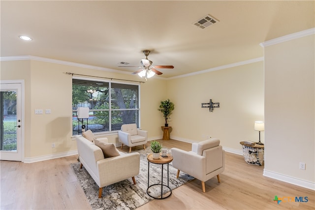 living room featuring ornamental molding, a wealth of natural light, ceiling fan, and light hardwood / wood-style flooring