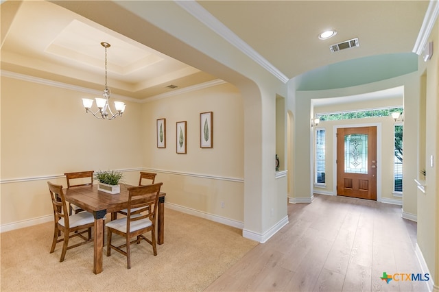 dining room with light wood-type flooring, a notable chandelier, and ornamental molding