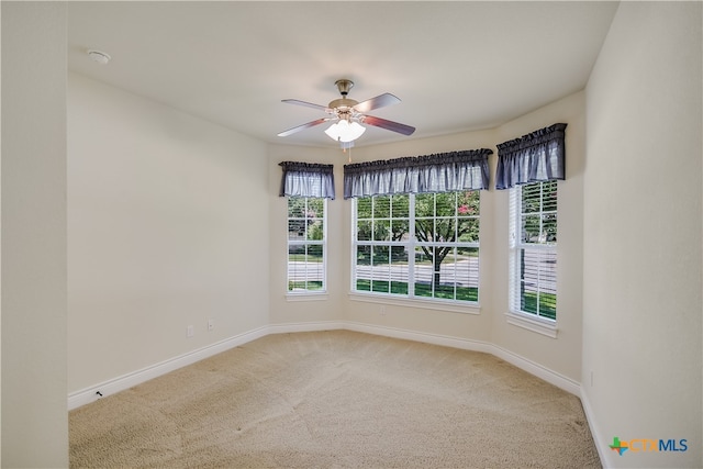 spare room with carpet flooring, ceiling fan, and plenty of natural light