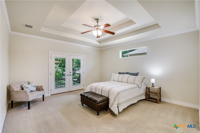 carpeted bedroom with ceiling fan, access to exterior, a raised ceiling, and french doors