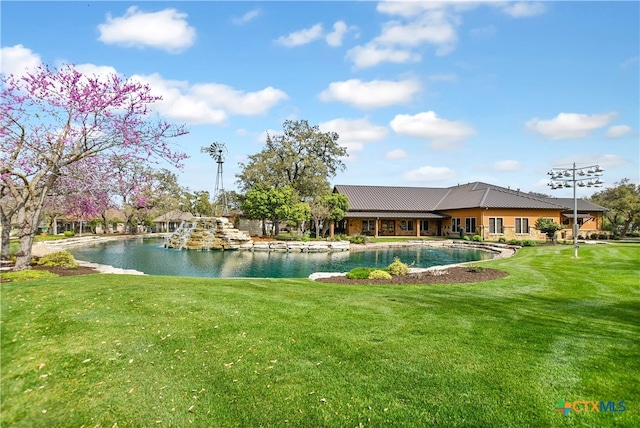 view of pool with a yard and a water view