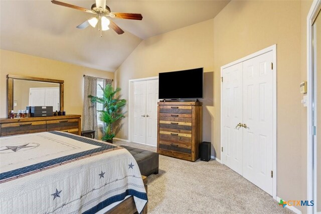 bedroom featuring carpet flooring, baseboards, multiple closets, and vaulted ceiling