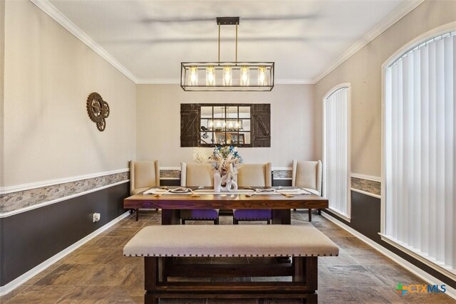 dining room featuring baseboards, stone finish flooring, and ornamental molding