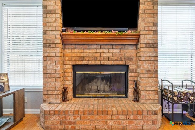 room details with a brick fireplace, baseboards, and wood finished floors