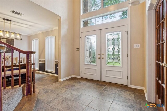 foyer entrance with a healthy amount of sunlight, stone tile floors, and visible vents