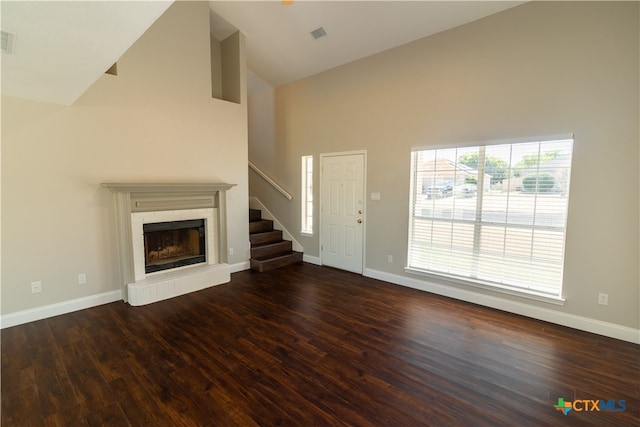 unfurnished living room featuring high vaulted ceiling and dark hardwood / wood-style floors