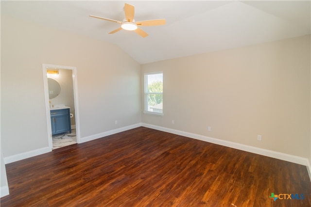 unfurnished bedroom featuring ensuite bathroom, dark hardwood / wood-style flooring, ceiling fan, and vaulted ceiling