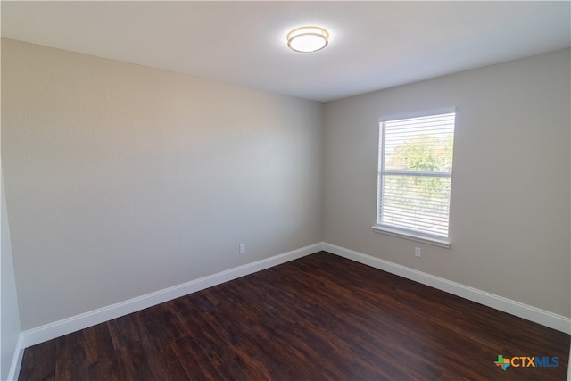 spare room with dark wood-type flooring