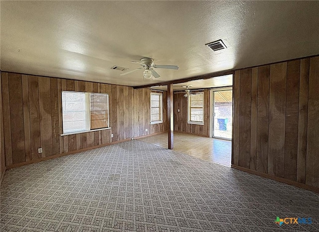 201 Dewald St, Copperas Cove, TX 76522 - unfurnished room featuring a ceiling fan, wood walls, healthy amount of natural light, baseboards, and a textured ceiling
