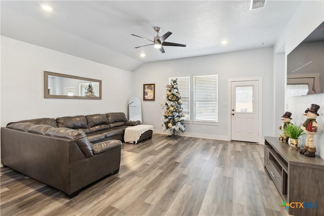 living room featuring ceiling fan, hardwood / wood-style floors, and lofted ceiling