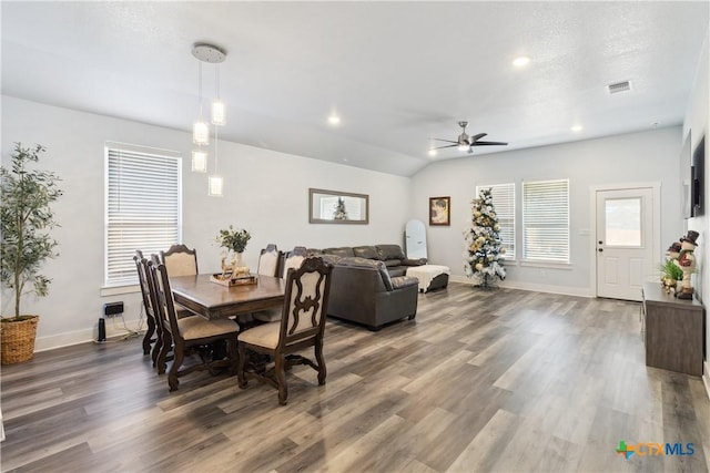 dining room with ceiling fan, a textured ceiling, dark hardwood / wood-style flooring, and lofted ceiling