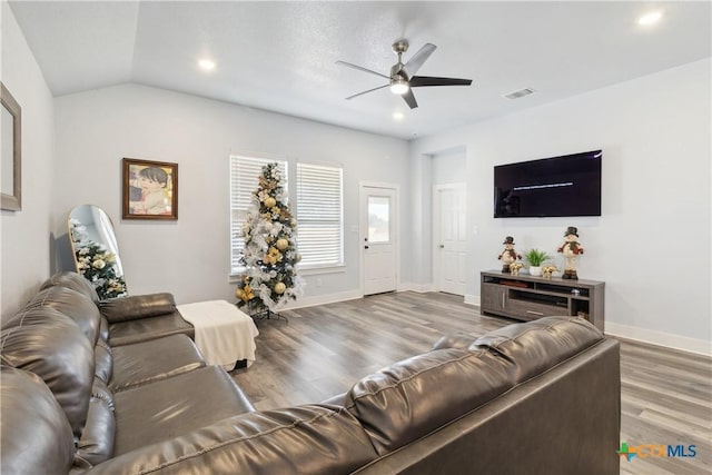 living room featuring hardwood / wood-style flooring, ceiling fan, and vaulted ceiling