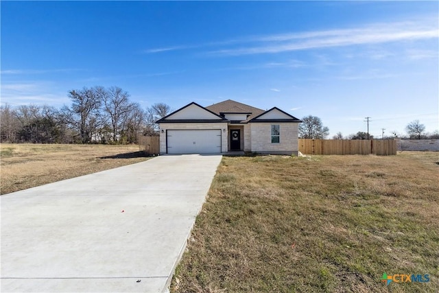 ranch-style home featuring a garage and a front lawn