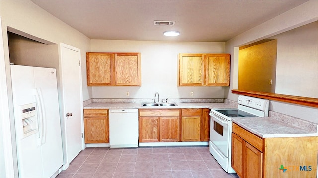 kitchen with light tile patterned floors, white appliances, and sink