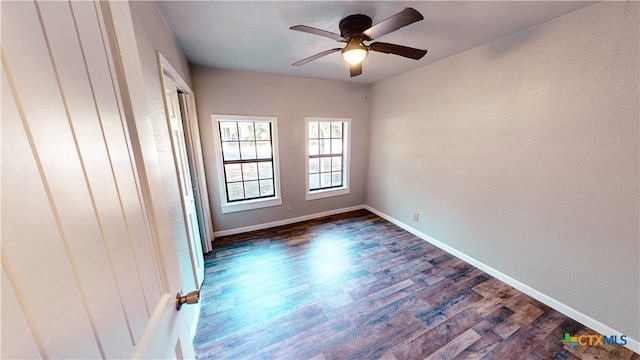 spare room with dark wood-type flooring and ceiling fan