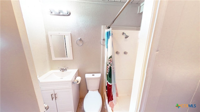 bathroom featuring walk in shower, vanity, and toilet