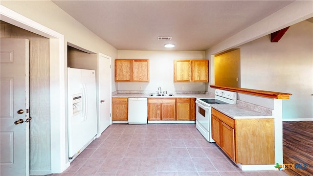 kitchen with kitchen peninsula, white appliances, and sink