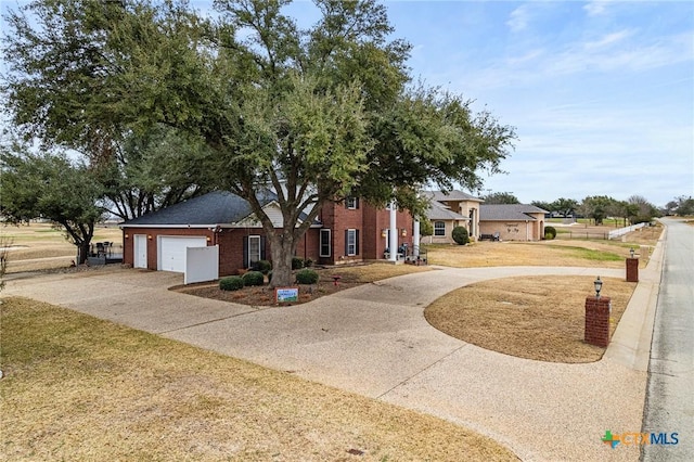view of front of house featuring brick siding, an attached garage, and driveway