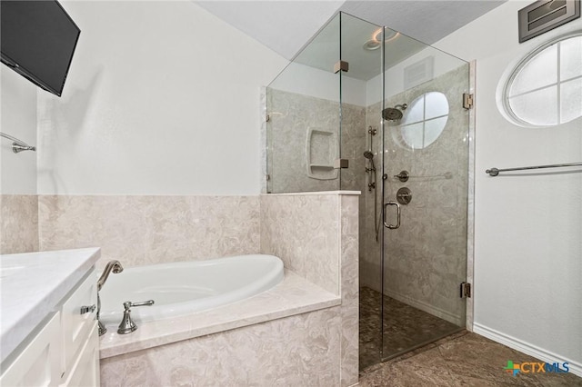 full bathroom featuring a shower stall, a garden tub, and vanity