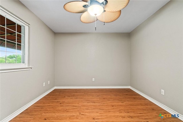 spare room featuring light wood-style flooring, baseboards, and a ceiling fan
