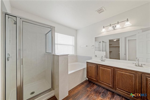 bathroom with vanity, hardwood / wood-style flooring, and shower with separate bathtub