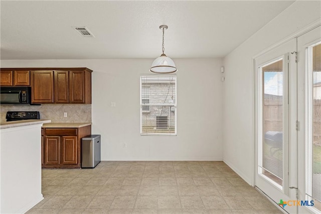 kitchen with pendant lighting, backsplash, and stove