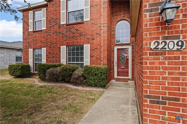 doorway to property with a yard