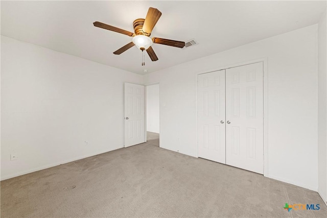 unfurnished bedroom with light carpet, a closet, and ceiling fan