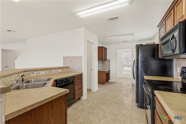 kitchen with backsplash, sink, and black appliances