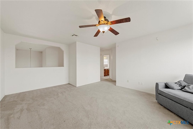 unfurnished living room featuring light colored carpet and ceiling fan