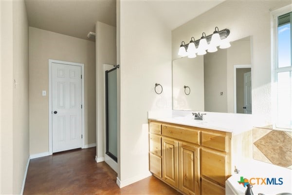 bathroom with vanity, concrete floors, and separate shower and tub