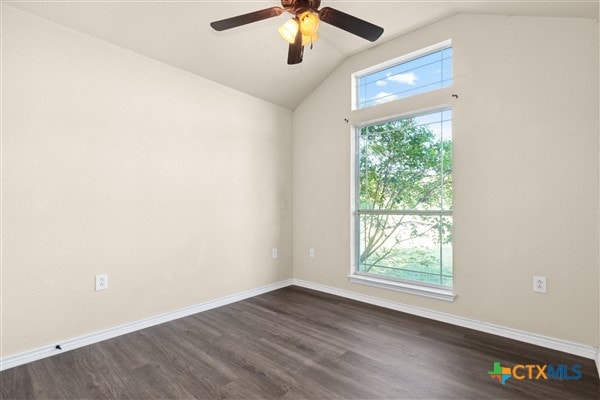 spare room with dark hardwood / wood-style flooring, ceiling fan, and vaulted ceiling