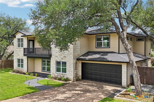 11611 Quarter Horse Trl, Austin, TX 78750 - view of front facade with a balcony, an attached garage, roof with shingles, driveway, and stone siding