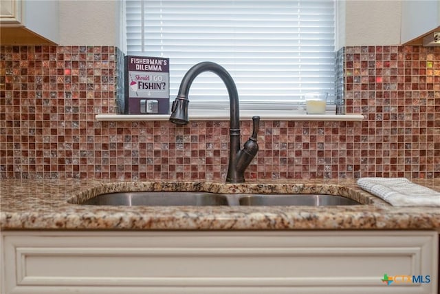 261 E Burgundy Bay Prt, Oconnor, TX 77982 - details with backsplash, light stone counters, and a sink