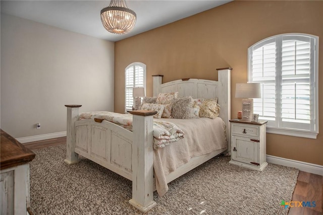 261 E Burgundy Bay Prt, Oconnor, TX 77982 - bedroom featuring baseboards, a notable chandelier, and wood finished floors