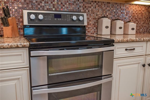 261 E Burgundy Bay Prt, Oconnor, TX 77982 - kitchen featuring decorative backsplash, light stone counters, and double oven range