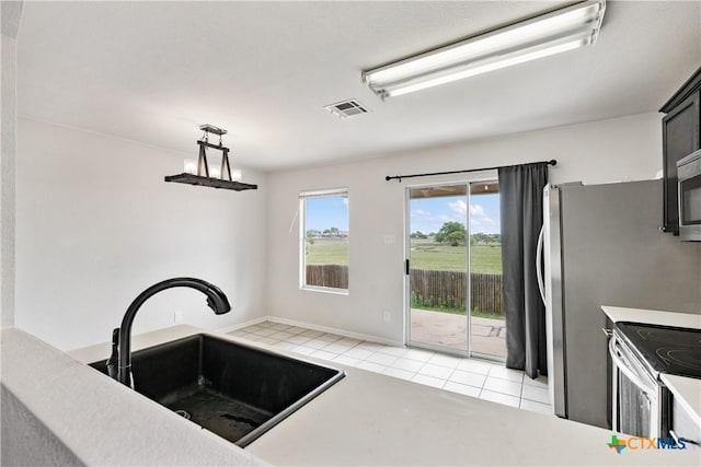 6008 Horne Dr, Killeen, TX 76542 - kitchen featuring stainless steel microwave, a sink, light tile patterned flooring, visible vents, and electric range