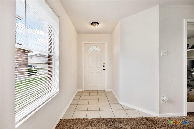 6008 Horne Dr, Killeen, TX 76542 - foyer featuring a wealth of natural light, light colored carpet, light tile patterned floors, and baseboards