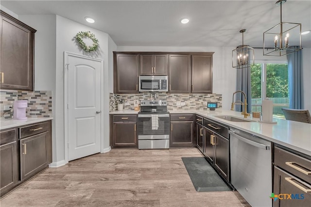 5010 Fallen Tree Dr, Temple, TX 76502 - kitchen featuring appliances with stainless steel finishes, a sink, dark brown cabinetry, a chandelier, and recessed lighting