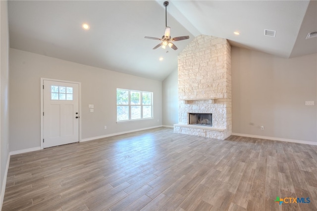 unfurnished living room with a fireplace, light wood finished floors, visible vents, high vaulted ceiling, and baseboards