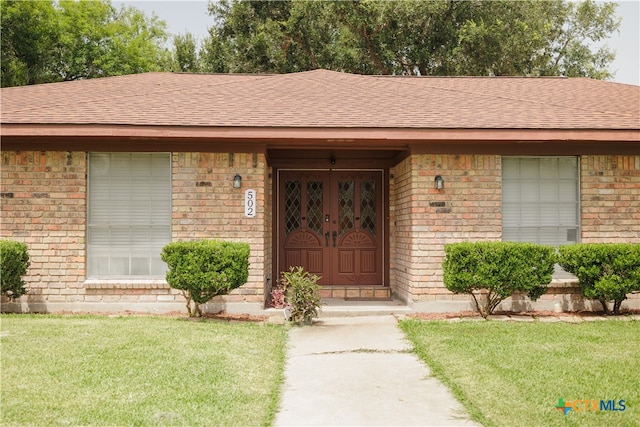 property entrance featuring a lawn