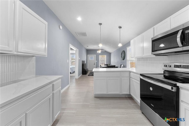 313 E Texas Ave, Killeen, TX 76541 - kitchen featuring stainless steel appliances, white cabinets, a peninsula, tasteful backsplash, and vaulted ceiling