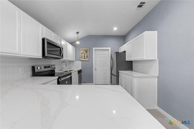 313 E Texas Ave, Killeen, TX 76541 - kitchen with stainless steel appliances, a sink, white cabinetry, light stone countertops, and lofted ceiling