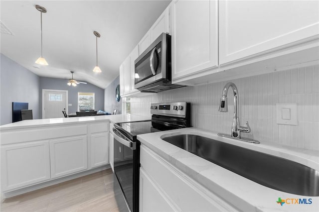 313 E Texas Ave, Killeen, TX 76541 - kitchen with appliances with stainless steel finishes, a sink, vaulted ceiling, white cabinetry, and tasteful backsplash