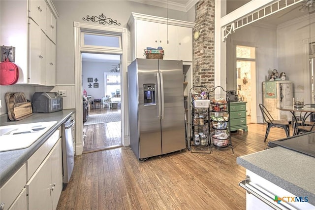 kitchen featuring stainless steel appliances, ornamental molding, and white cabinets