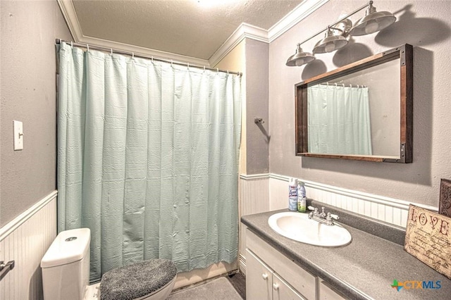 bathroom with vanity, crown molding, a textured ceiling, and toilet