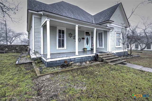 view of front of property with a front yard and covered porch