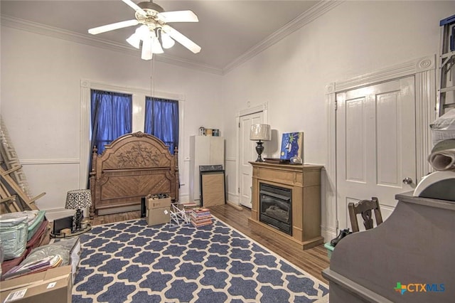 bedroom with hardwood / wood-style flooring, ornamental molding, and ceiling fan