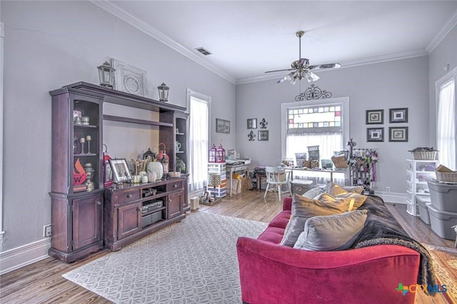 living room featuring crown molding, wood-type flooring, and ceiling fan